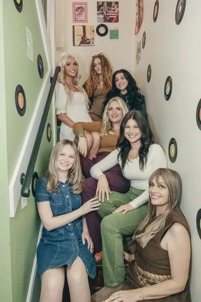 The Studio 71 team on the salon's vintage record-lined staircase
